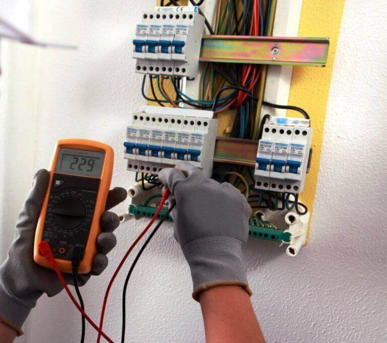 Eletricista trabalhando em quadro elétrico